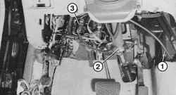 При снятой обивке видны идущий от аккумуляторной батареи силовой провод (1) пространства для ног водителя; вал (2) рулевого колеса с удлинителем для регулируемой рулевой колонки; красное штекерное соединение (3) к подушке безопасности
